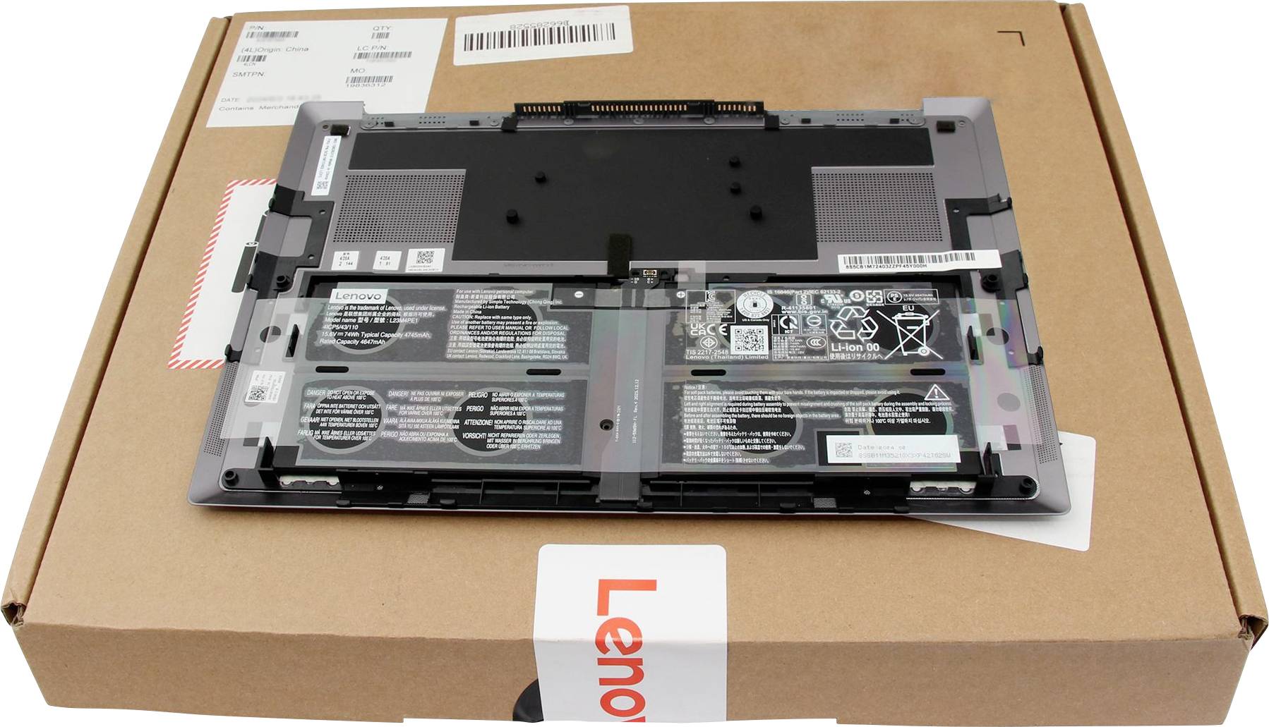 Et bærbar computer batteri ligger på en Lenovo æske, der viser batterispeficikationer og sikkerhedsikoner.