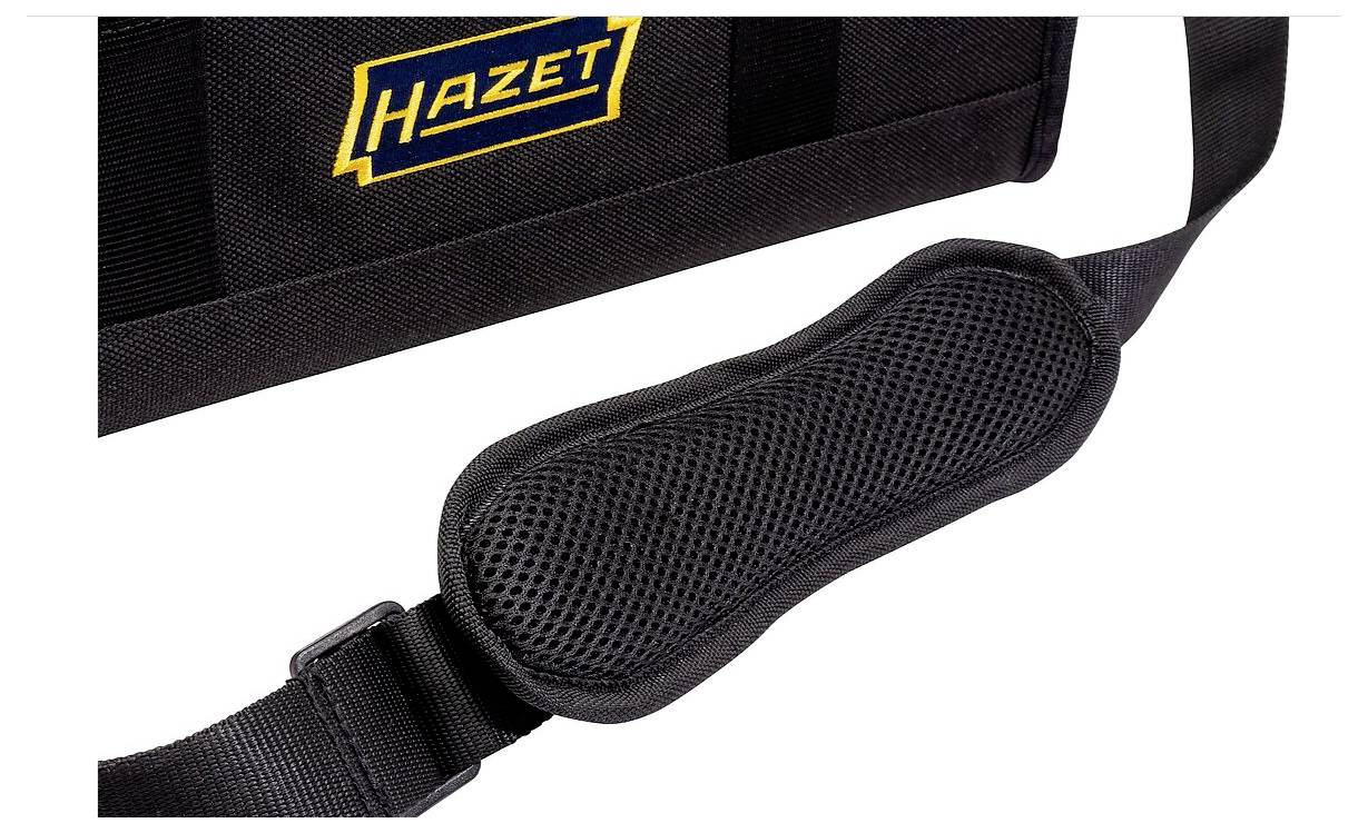 Et nærbillede af en sort skulderstrop, der er fastgjort til en taske, med et polstret parti for at give komfort. Tasken har et blåt og gult 'Hazet' logo.