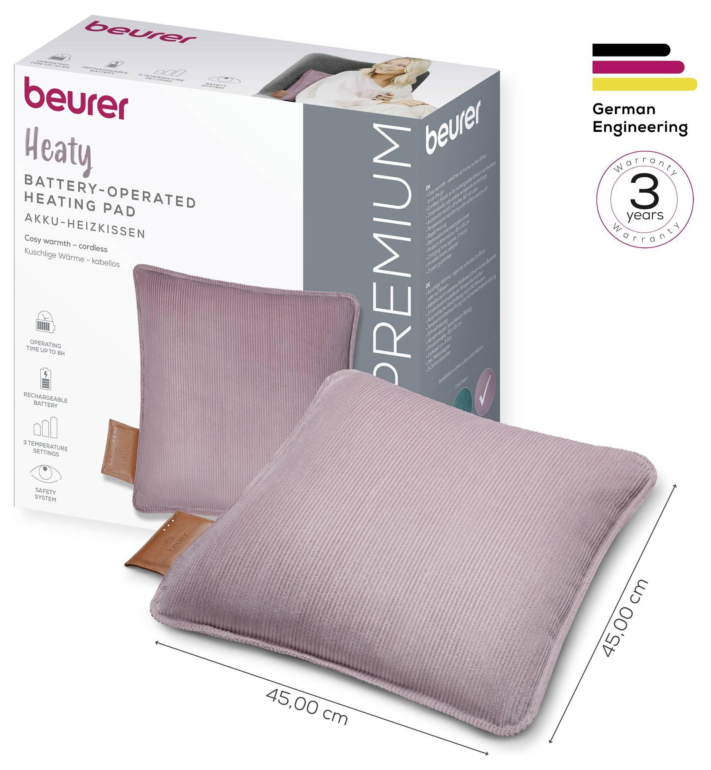 Beurer batteridrevet varmepude i pink, måling 45x45 cm. Inkluderet produktboks med funktioner og garantioplysninger fremhævet.