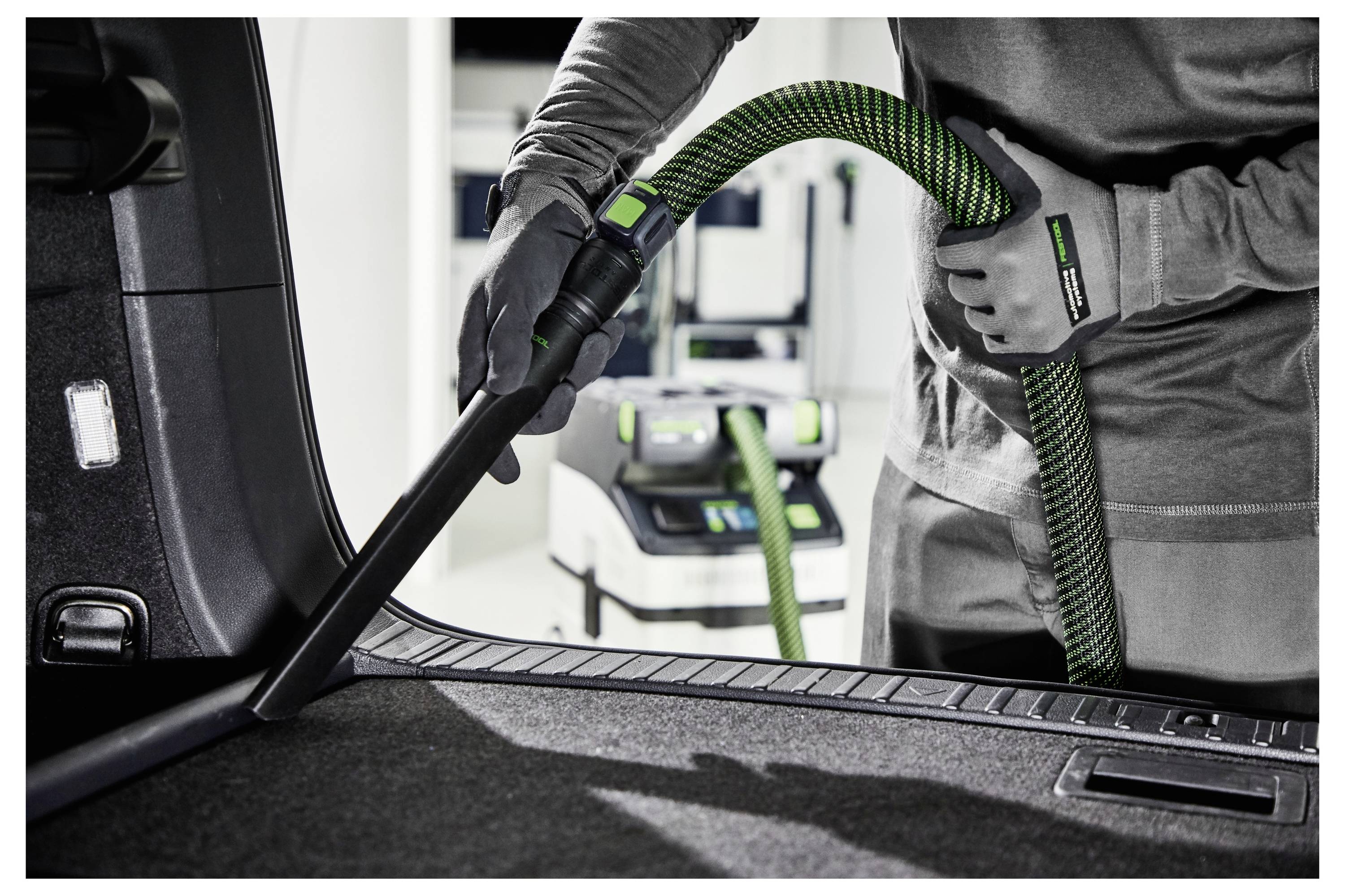 En rektangulær elektrisk slibemaskine mærket 'Festool RS 300 EQ' glatter en træoverflade, hvilket indikerer brug inden for træbearbejdning eller finish-arbejde.