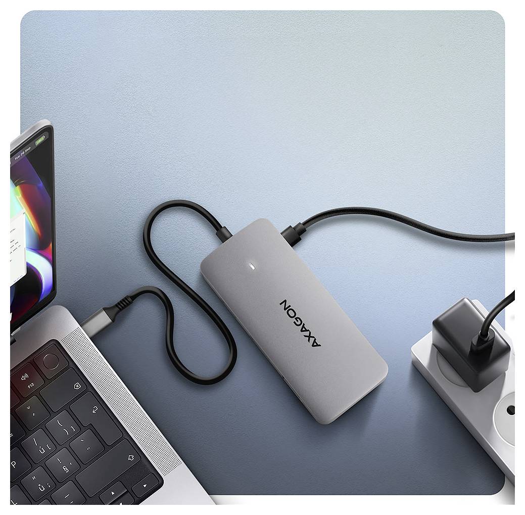 'En grå bærbar oplader forbundet til en bærbar computer og tilsluttet en strimmelstikkelses på en lyseblå baggrund.'