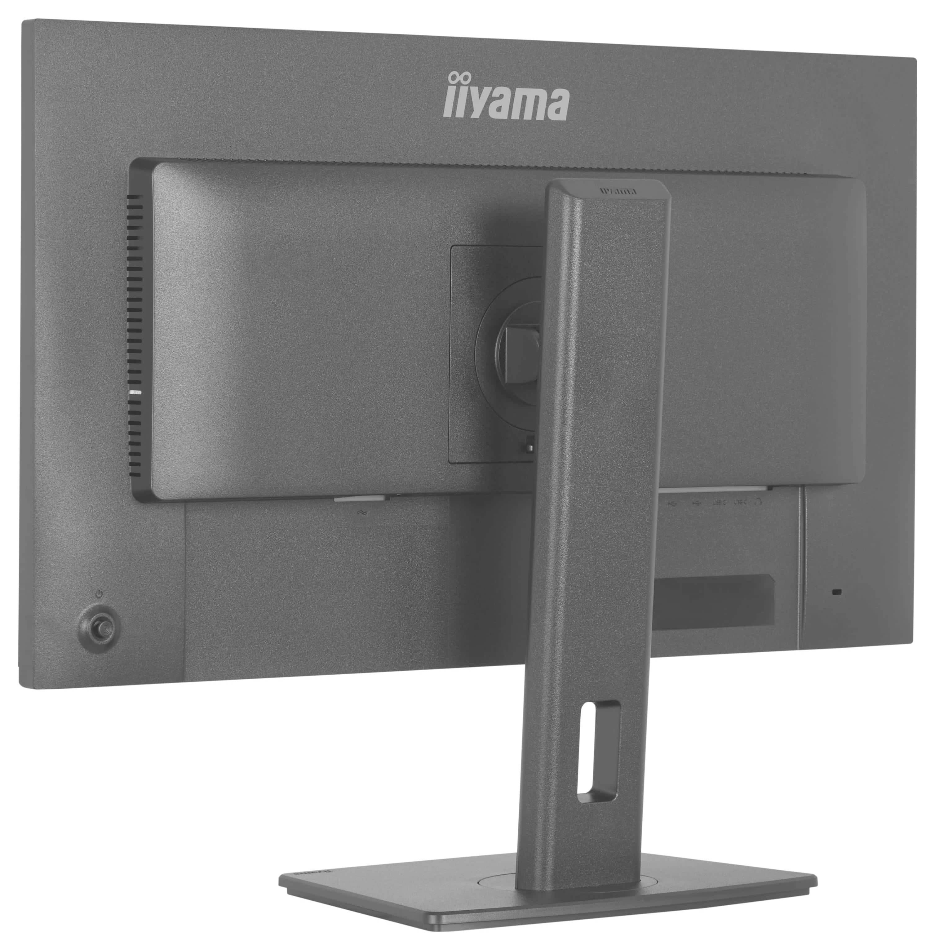 En grå computerskærm set bagfra, der står på en rektangulær base med mærkenavnet trykt på det øvre bagpanel.