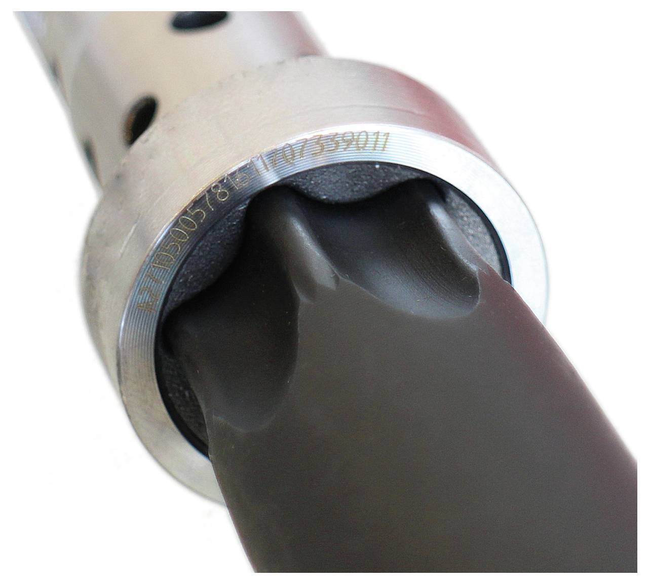 Nærbillede af en metallisk cylindrisk genstand med et sort gummielement, muligvis en del af en mekanisk eller automobilkomponent.