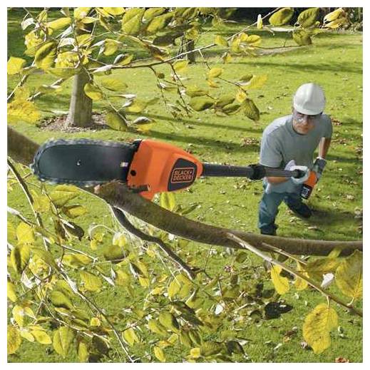 En person trimmer græs i en have ved hjælp af en orange trimmer, mens hun står foran et træ hegn på en solrig dag.