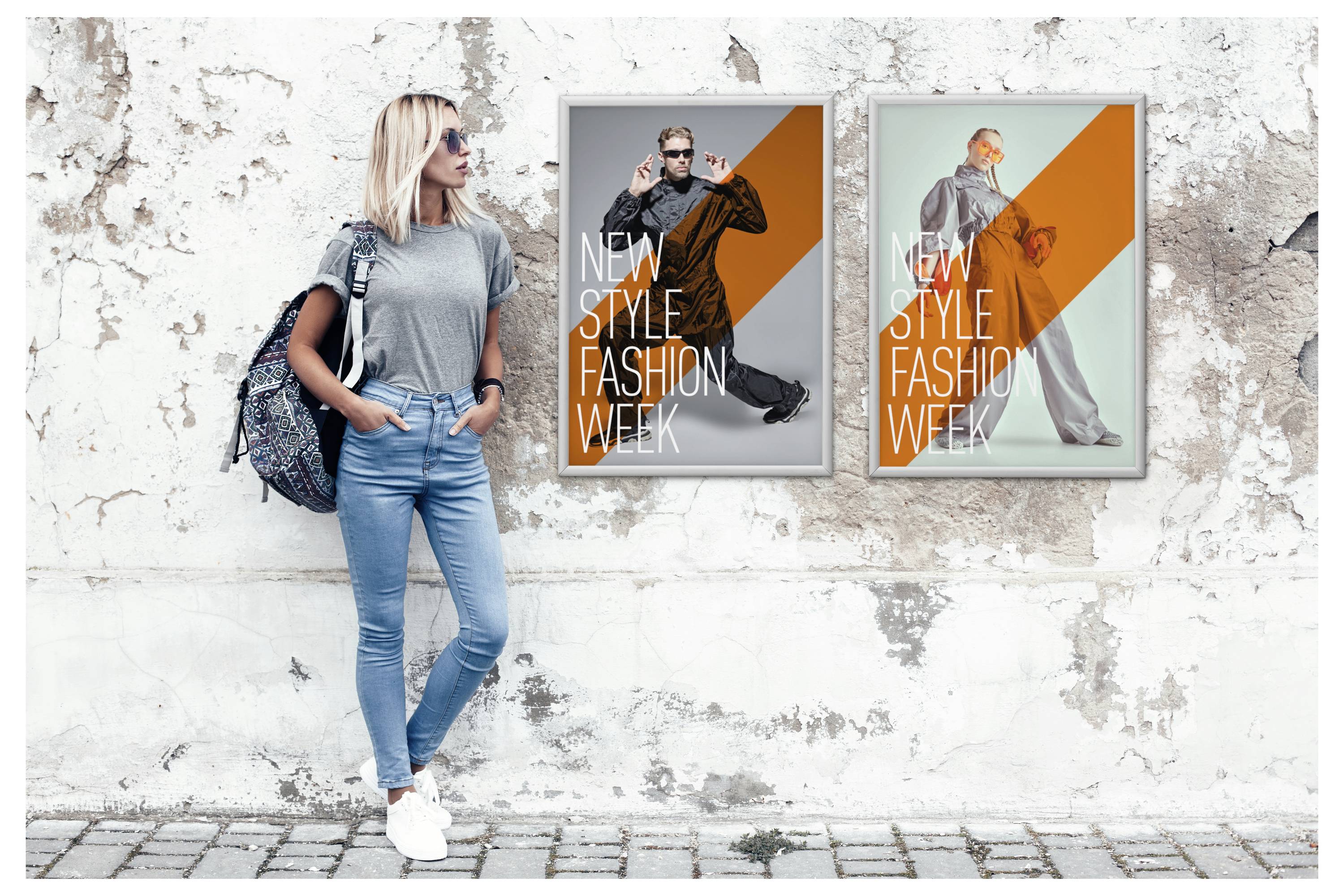 En kvinde i afslappet påklædning står op ad en slidt væg med to plakater, der promoverer 'New Style Fashion Week', som viser stilfulde modeller.