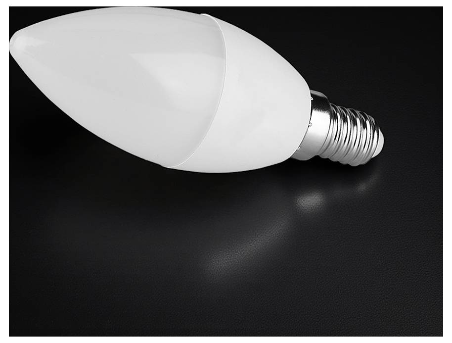 En hvid LED-pære ligger på siden mod en mørk baggrund.