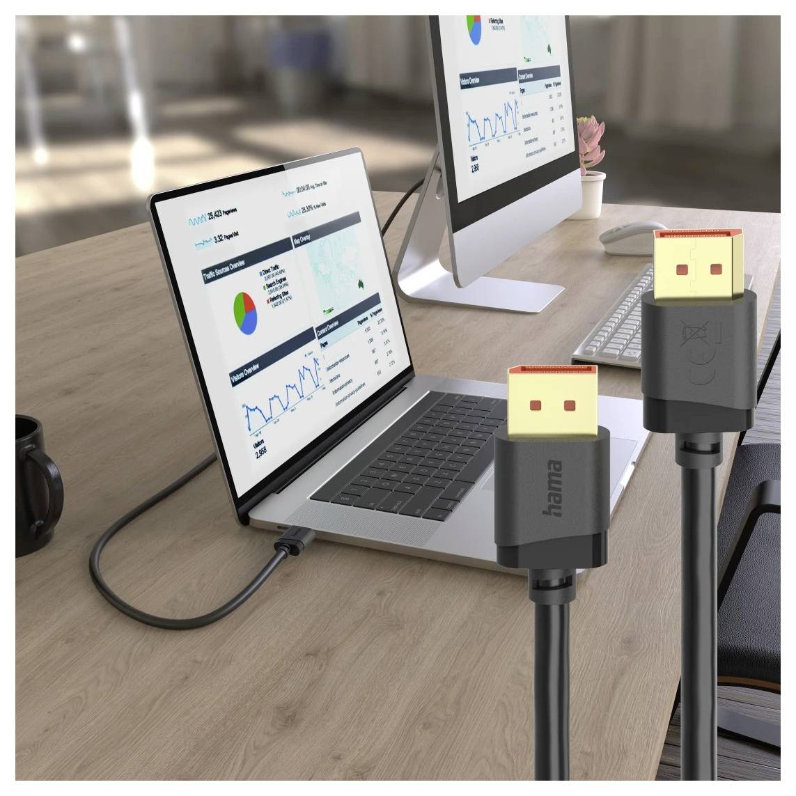 To USB-C-kabler tilsluttet en bærbar computer og en stationær skærmmonitor på et skrivebord, hvor skærmene viser analytikerdashoboards.
