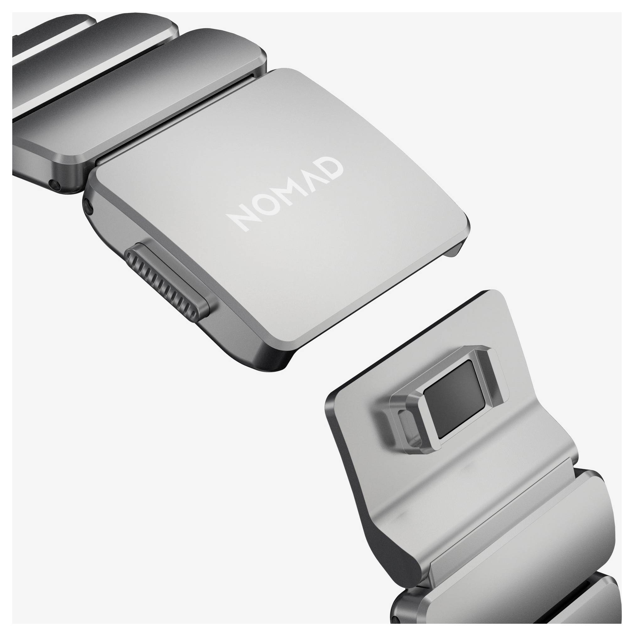 Nærbillede af produktet viser en sølvfarvet og sort NOMAD metalenhed med et hængslet eller sammenklappeligt design, vist fra front og side.