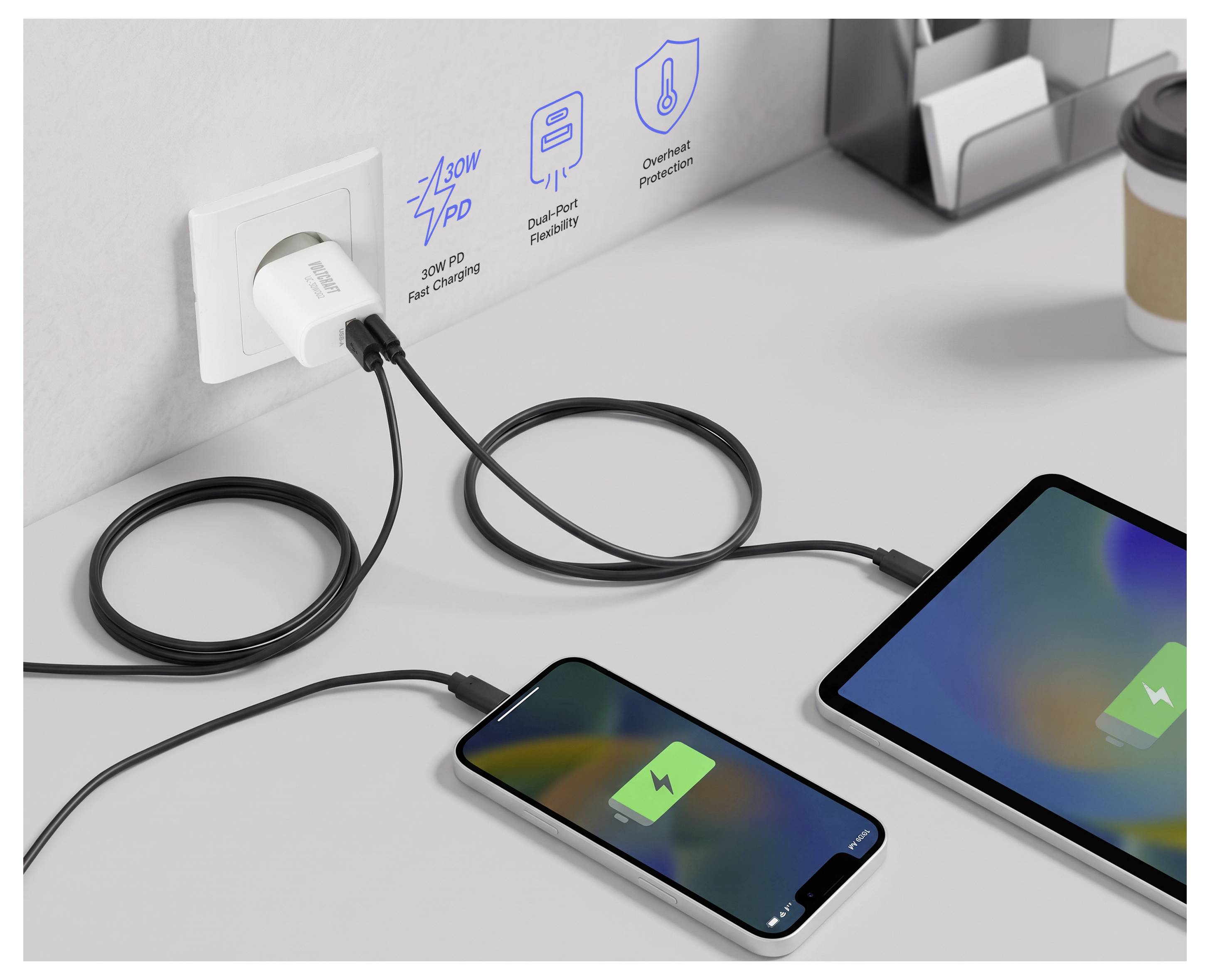 To enhed oplade fra en stikkontakt via sorte kabler, med en telefon og tablet, der viser batteriikoner og labels for 30W hurtiglading, dual-port-fleksibilitet og overophedningsbeskyttelse.