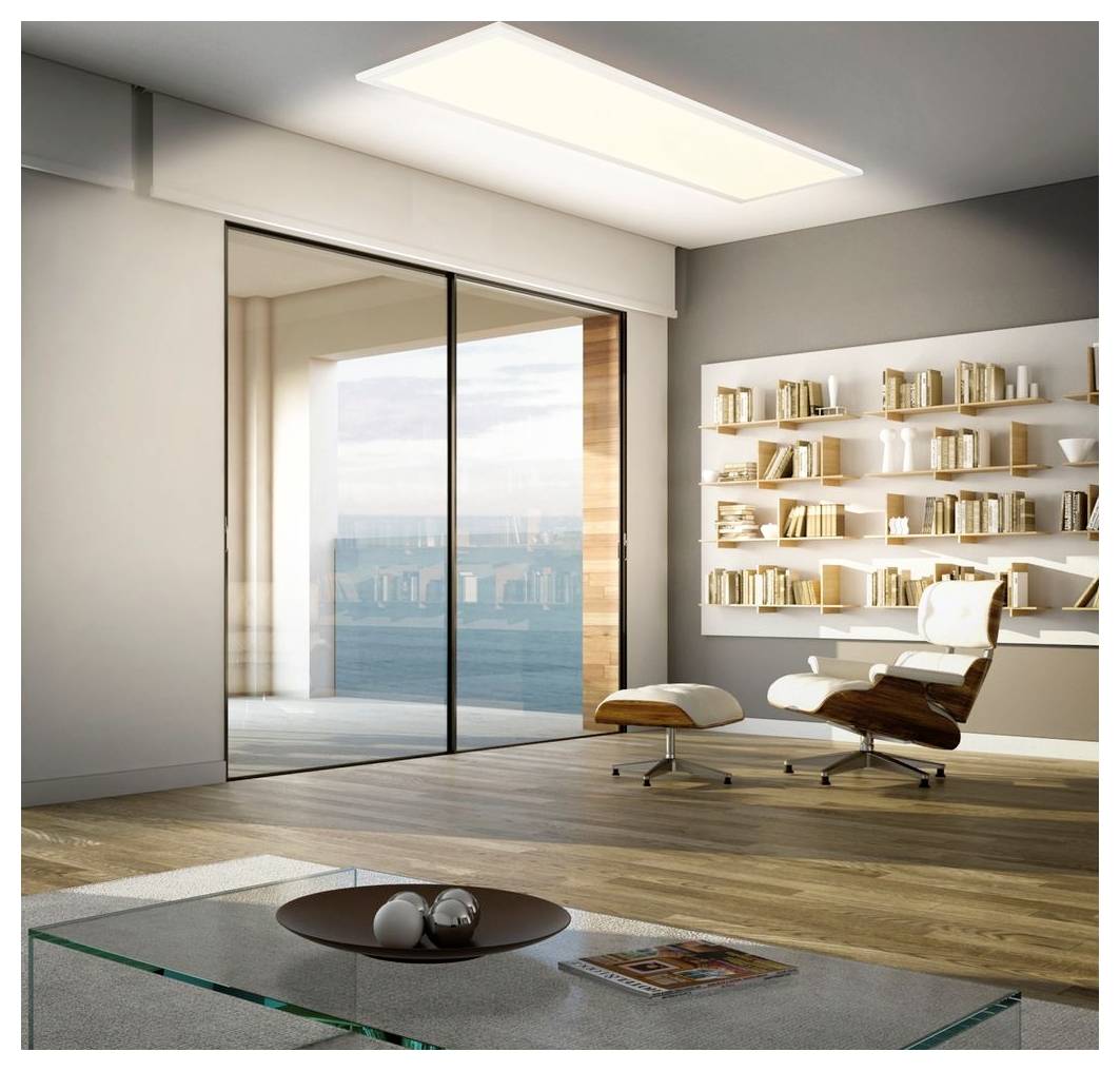 Moderne stue med glasdøre fra gulv til loft, loungestol og skammel, væghylder til bøger og et lavt glascaféebord med udsigt til vand udenfor.