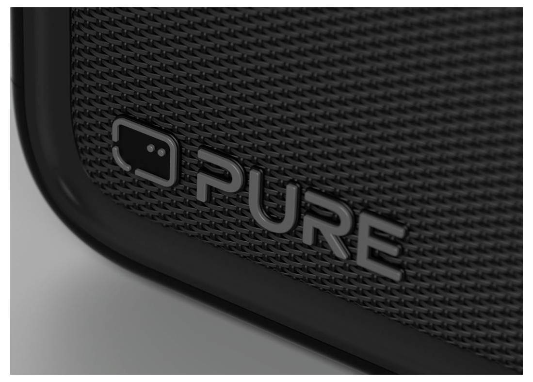 Nærbillede af et sort struktureret højttalergitter med 'PURE'-logoet og ikon på forsiden hjørne.