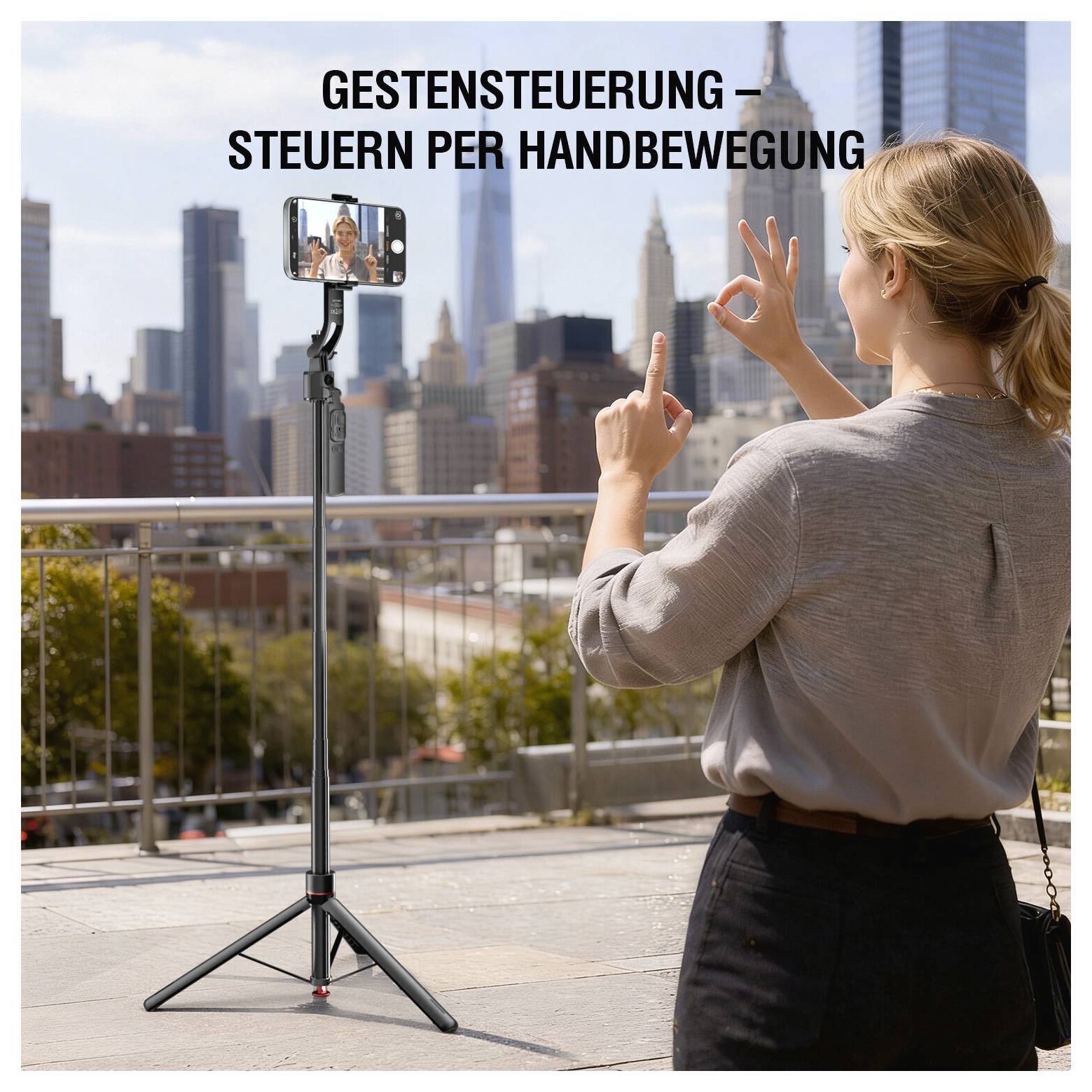 En kvinde bruger håndbevægelser til at styre en smartphone på et stativ; tysk tekst lyder 'GESTENSTEUERUNG – STEUERN PER HANDBEWEGUNG' mod en bystakline.