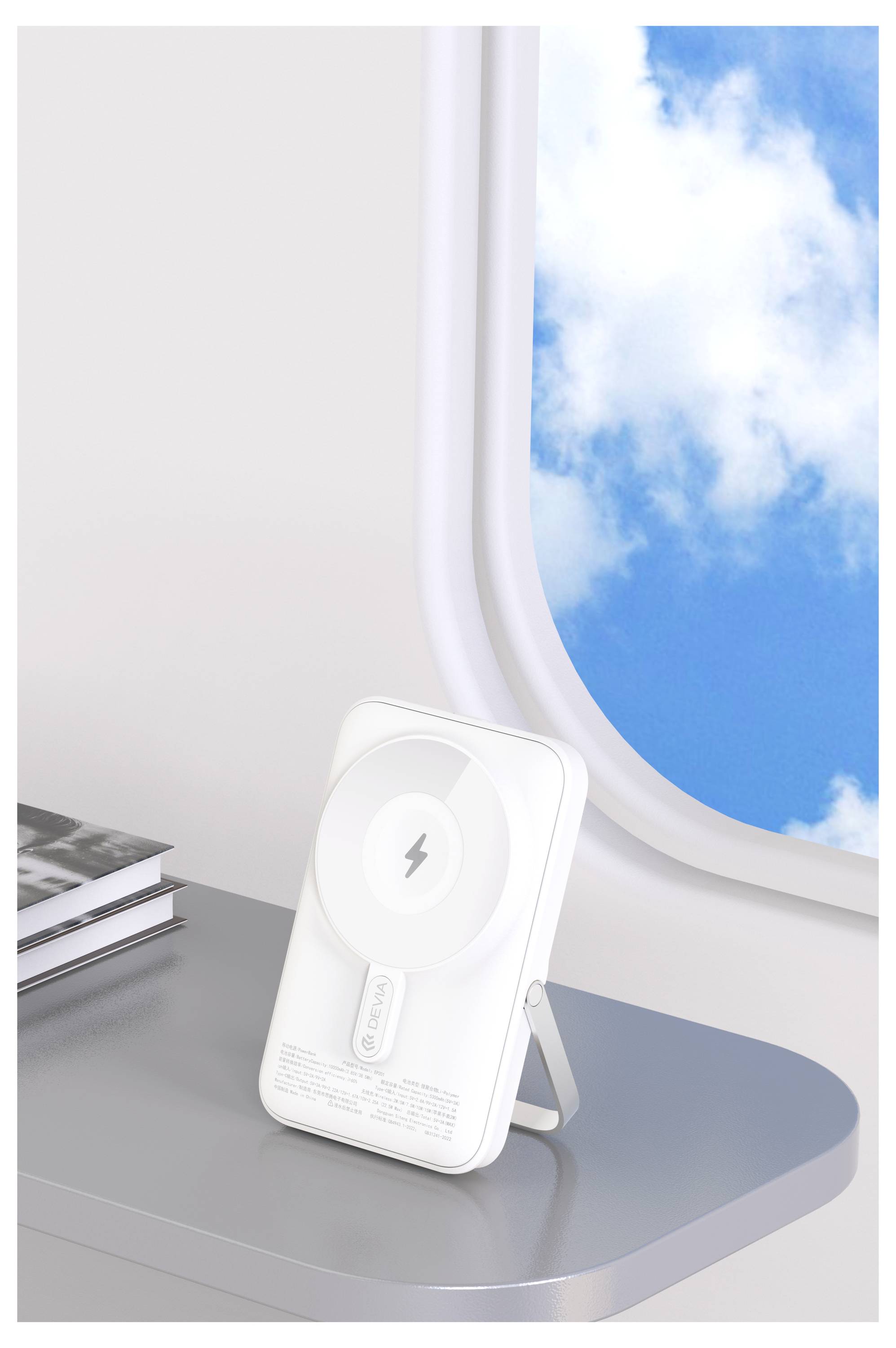 Hvid trådløs opladningsstation på et skrivebord ved et flyvindues, der antyder bærbar telefonopladning under rejse.