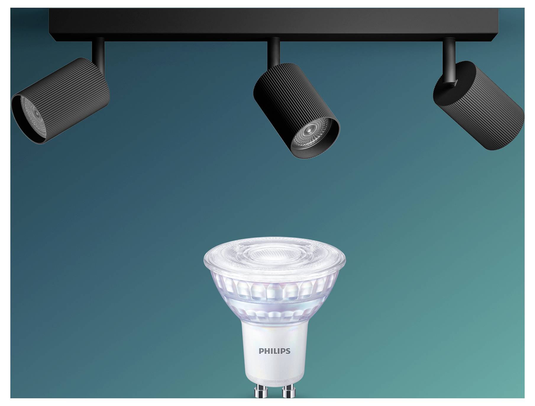 Philips LED-spotlightpære centreret under tre loftspotlights på en blågrøn baggrund.