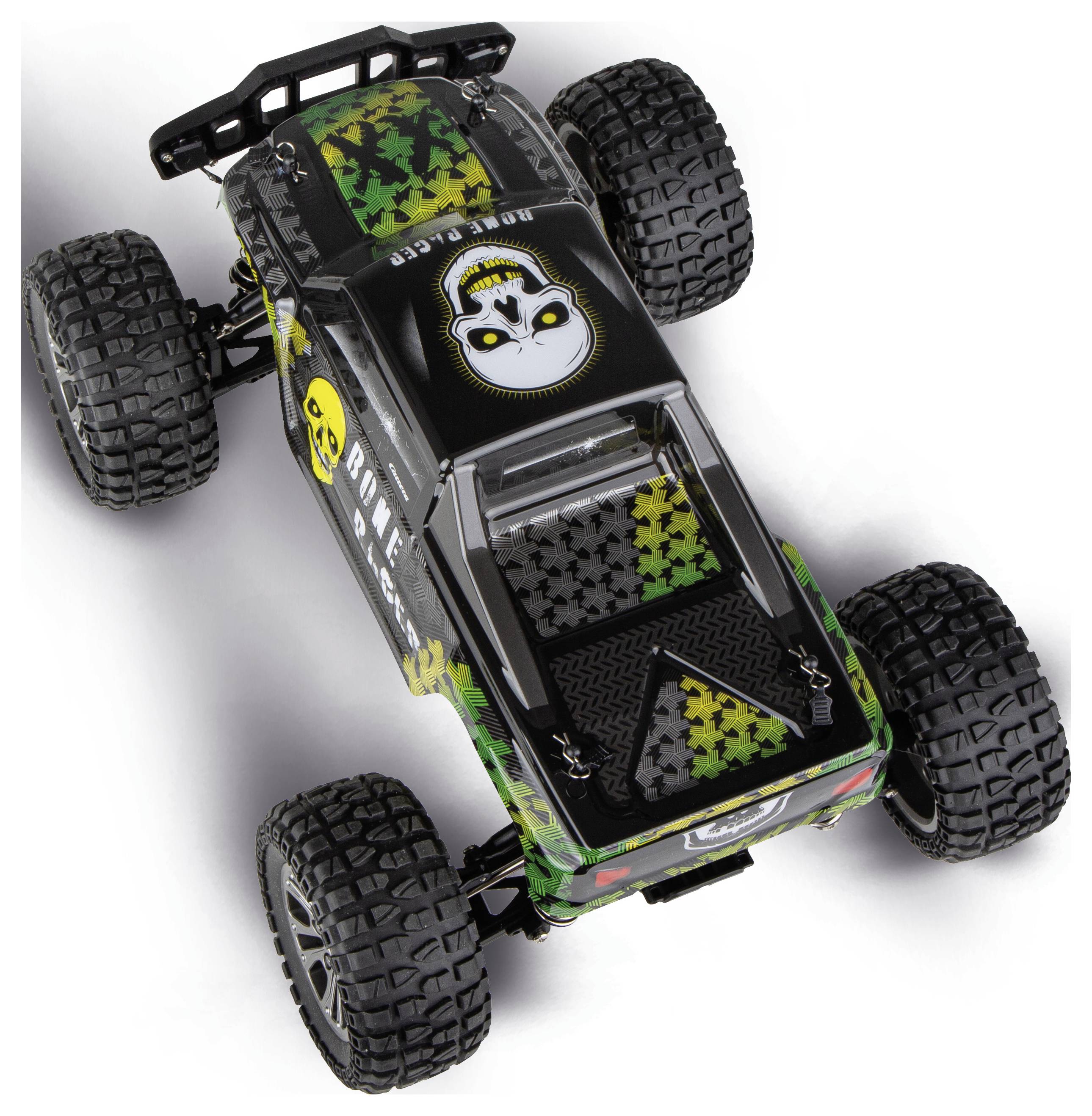 Topview af en sort fjernbetjent terræn-buggy med store knobbede dæk og dødningehoved-tematiseret grøn camouflage-grafik på hvid baggrund.