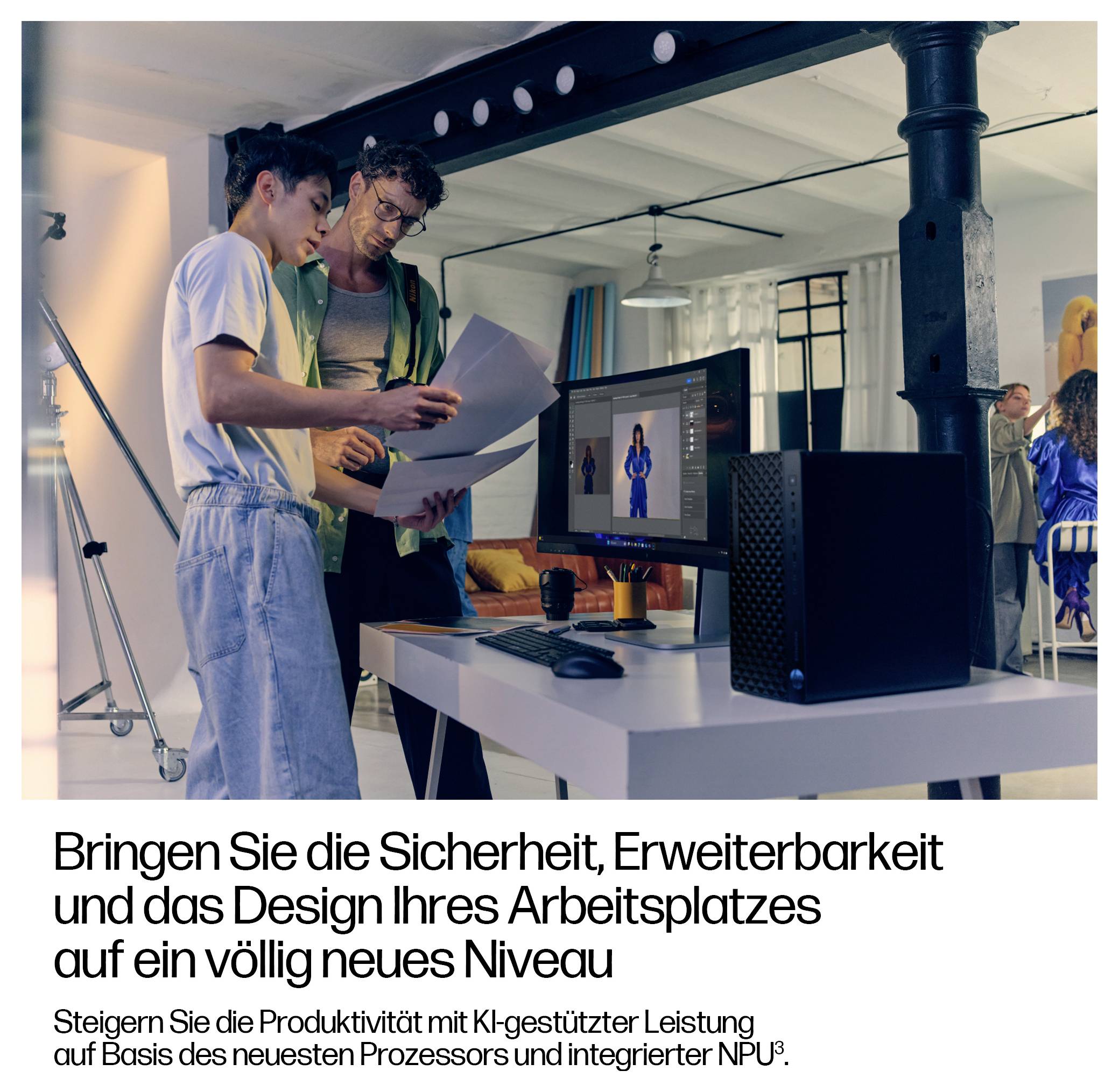 To people vurderer designudtryk ved siden af en stationær computer på et moderne kontor; tysk annoncetekst fremmer arbejdspladsens sikkerhed, udvidelsesmuligheder, design og AI-ydeevne med en ny processor og integreret NPU.