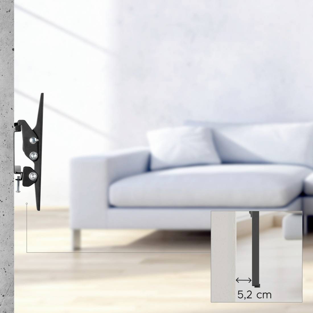 Vægmonteret TV-beslag vist i sidevisning ved siden af en uskarpt sofa, med en indsats, der måler beslaget dybtliggende på 5,2 cm.