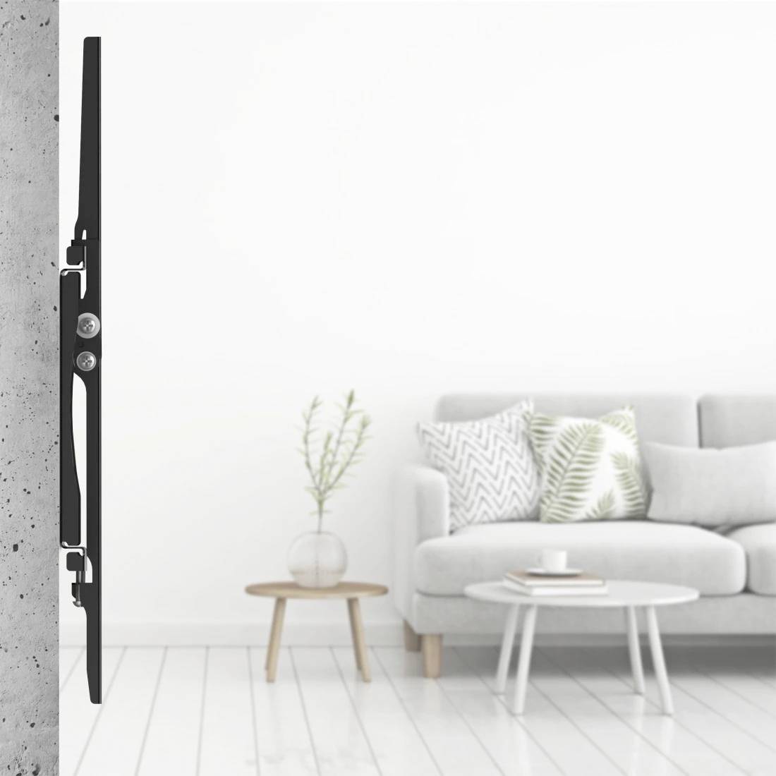 Sidevisning af en fladskærms-tv monteret tæt på en betonvæg, der viser et lyst minimalistisk stuerum med sofa, borde og indretning.