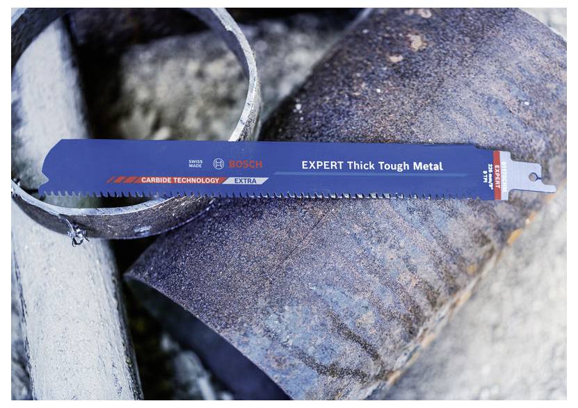 Bosch Expert Thick Tough Metal savlemetalblade hviler på et rustent metalrør, vist i en næropsnapning af en industriel setting.