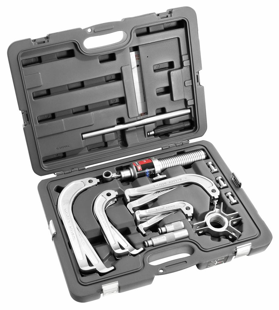Åben hårdkoffer med et hydraulisk gear puller-sæt, inkluderet puller-arme, pressskrue og forskellige tilbehørsdele i formet skum.