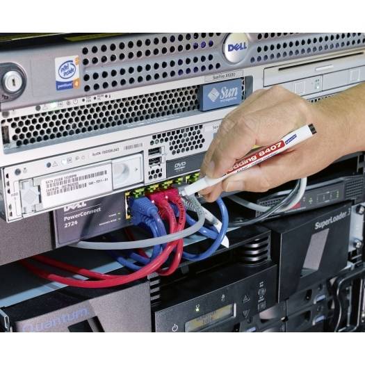 Håndtilslutning af et netværkskabel til en serverrek, tilslutning af farvede Ethernet-kabler på stablet Dell- og Sun-udstyr i et datacenter.