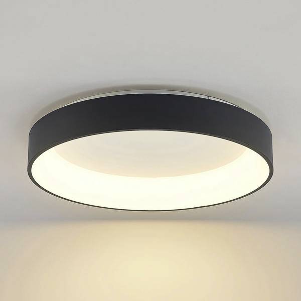 Rund sort loftslampe med en lyst hvidt spreder, monteret på et hvidt loft.