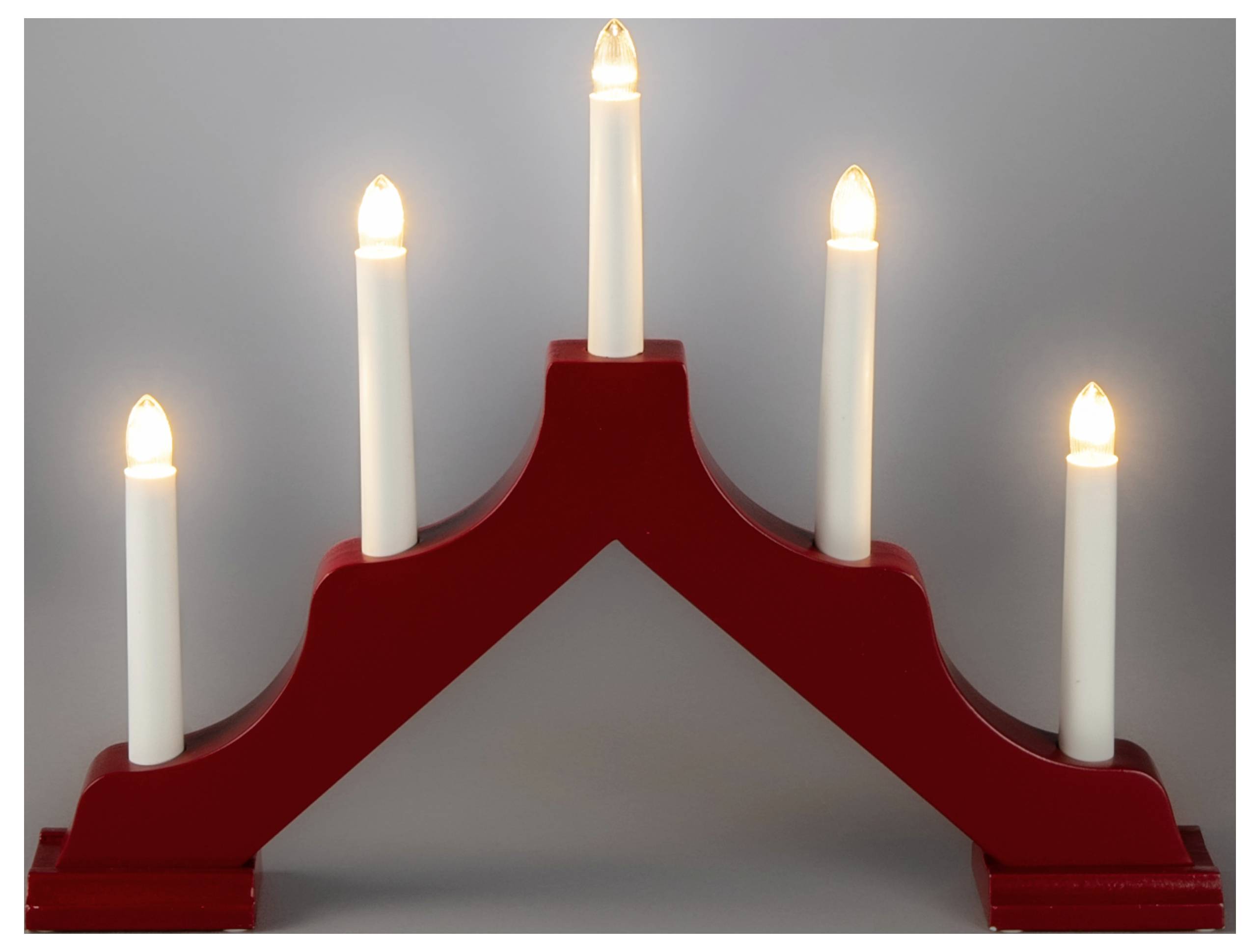 En rød træ-adventslysestage med fem tændte hvide lys arrangeret på rad, højeste i midten.