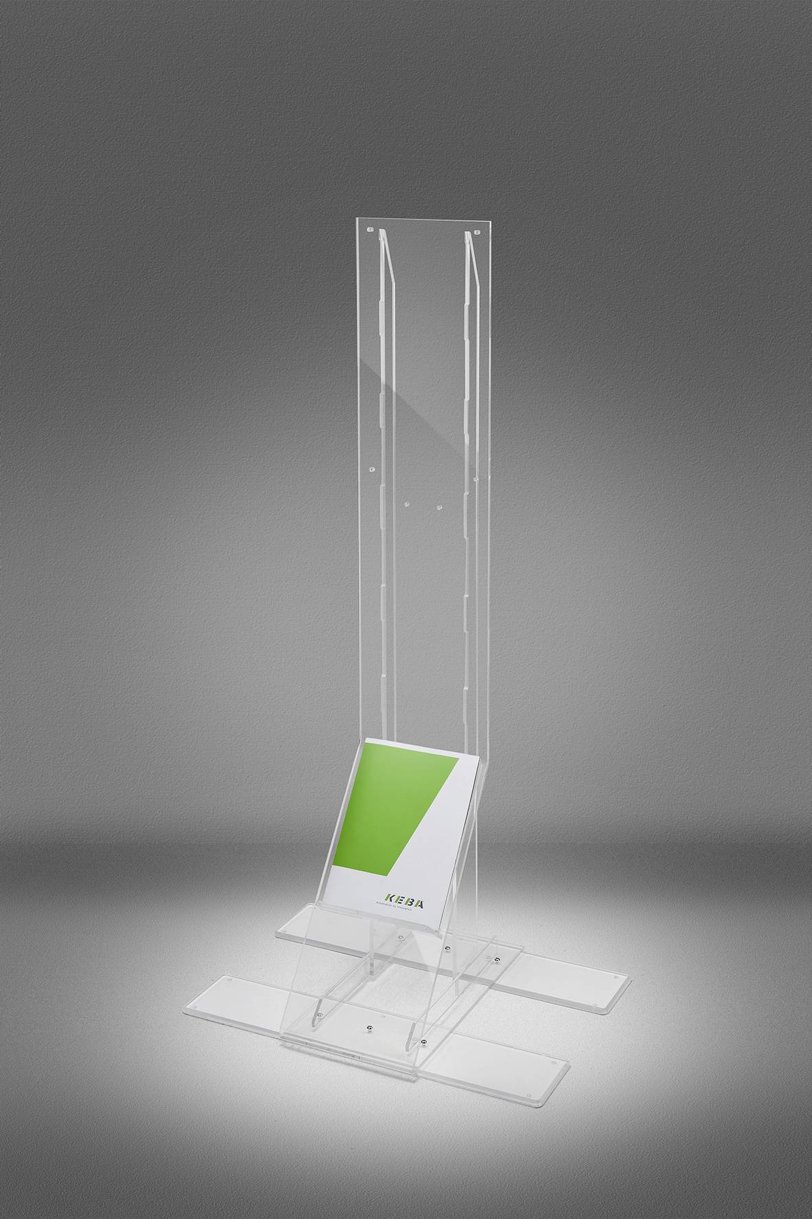 Klar akryl gulvdisplaystand med en skrå base, der holder et grønt-og-hvidt skilt eller brochure, vist mod en grå studiobaggrund.