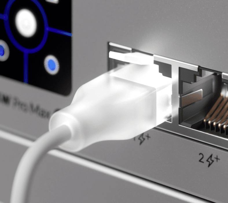 Hvidt Ethernet-kabel tilsluttet en enheds netværksport ved siden af en anden tom port og statuslamper.