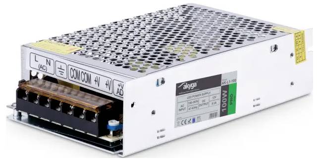 Sølvmetallisk AC-til-DC strømforsyningsenhed med terminalblok og ventilationshul, mærket '100W' og '24V'.