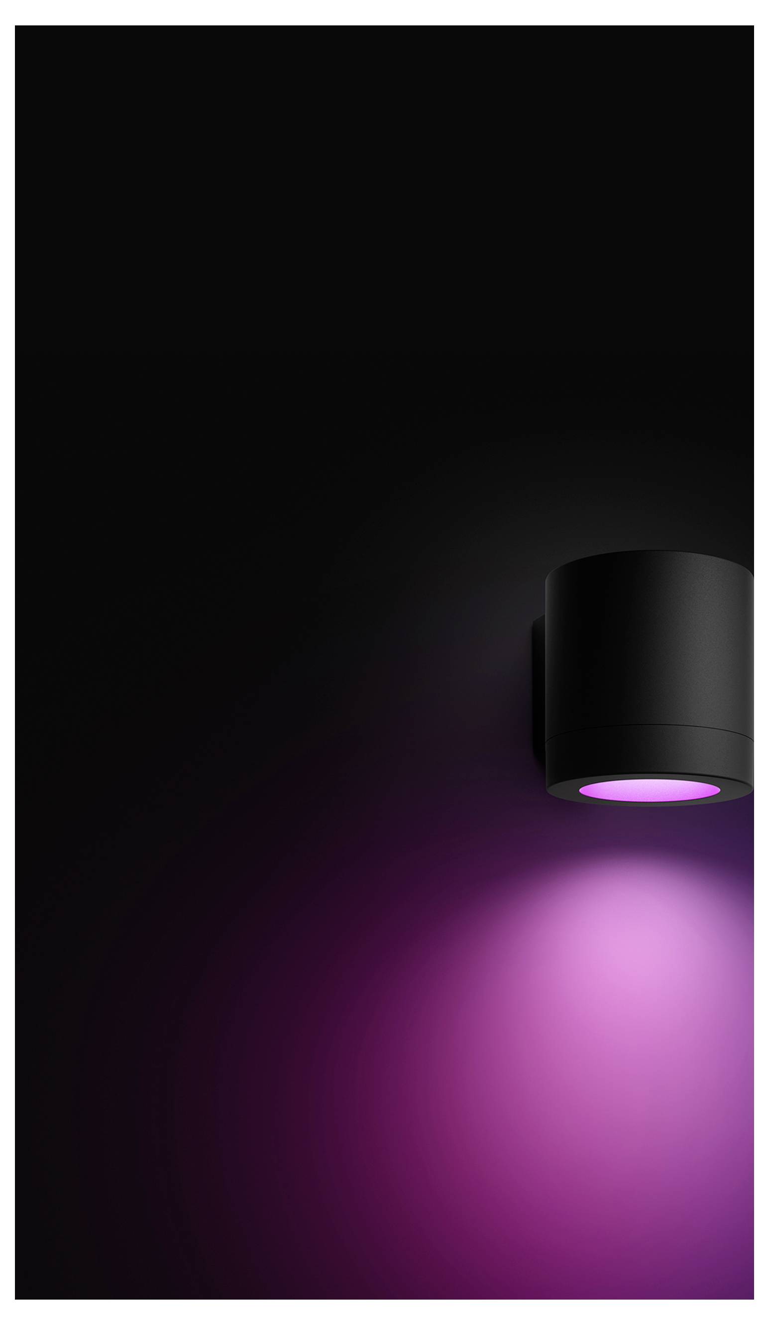 Sort væglampe med en pink-lilla glød, der kaster et blødt spotlight nedad i et mørkt rum.