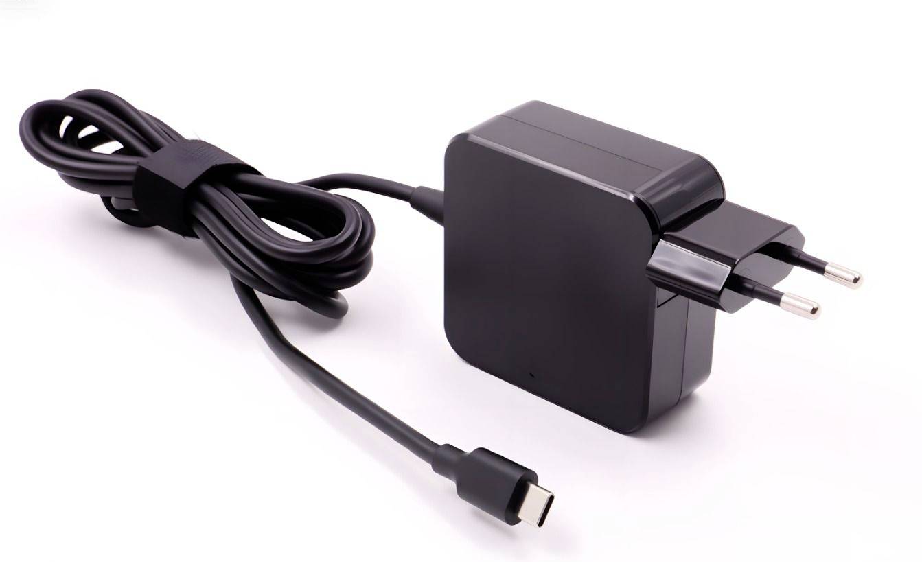 Sort vekselstrøm-strømadapter med tilsluttet kabel og USB-C-stik på hvid baggrund