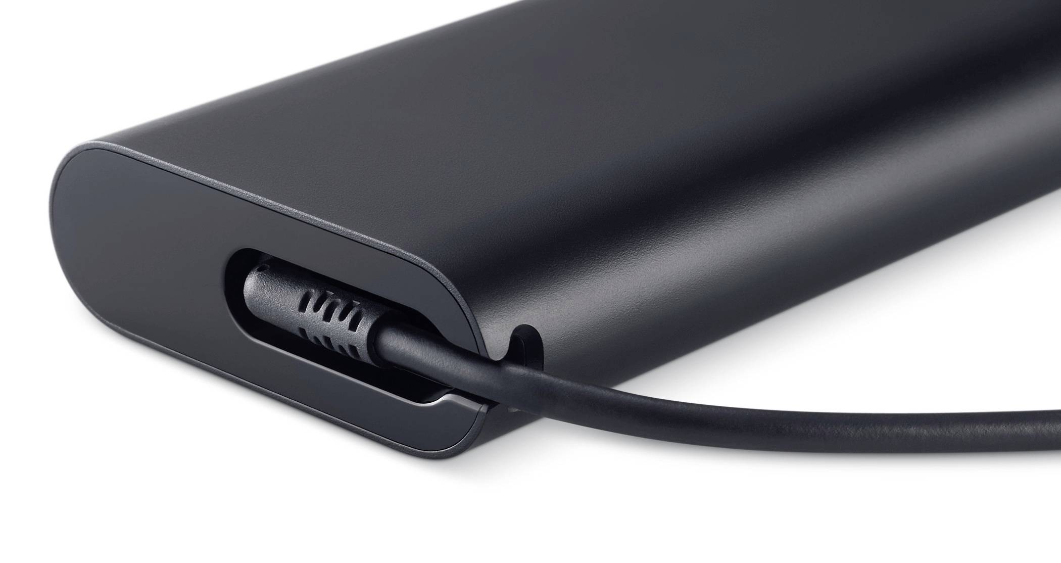 Tætbillede af en sort powerbank eller batteripack med et opladningskabel tilsluttet dens sideport.