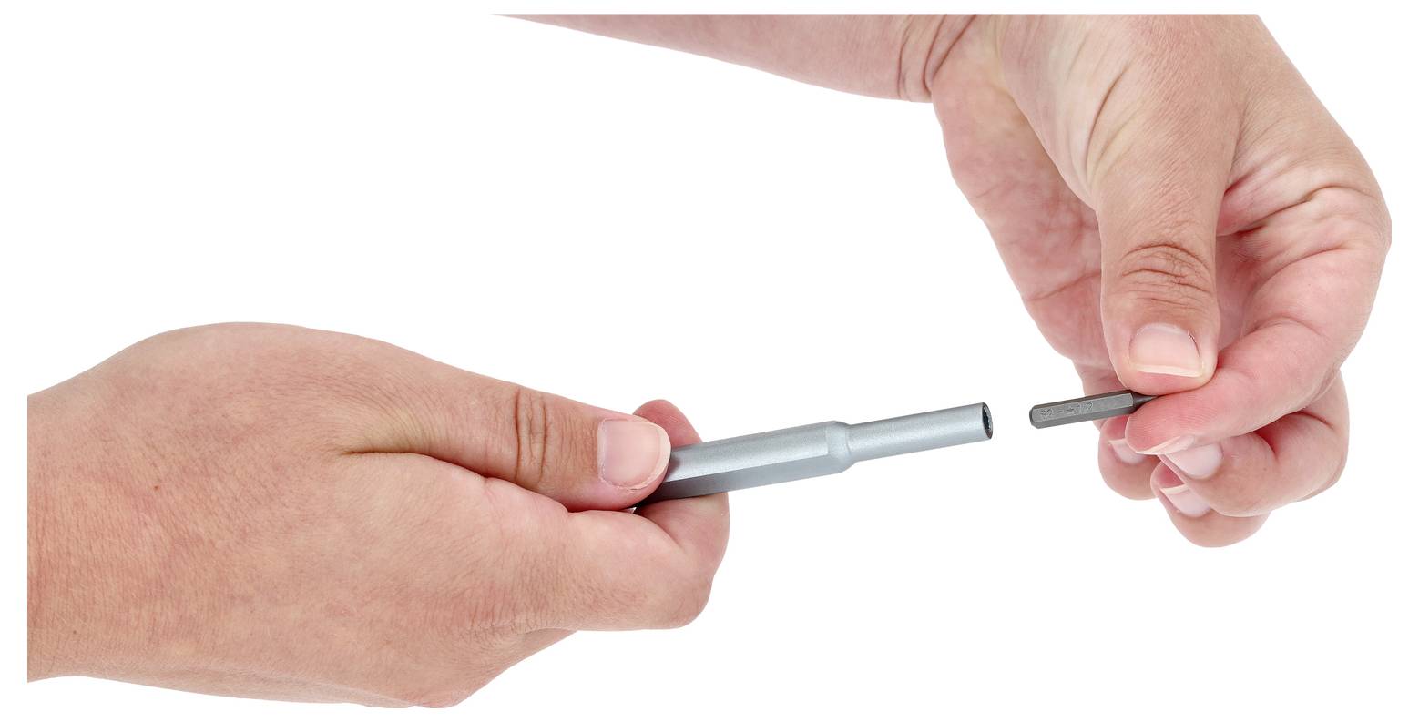Hænder, der afbryder et gråt kabel, med stikket trukket fra hinanden i midten mod en hvid baggrund.