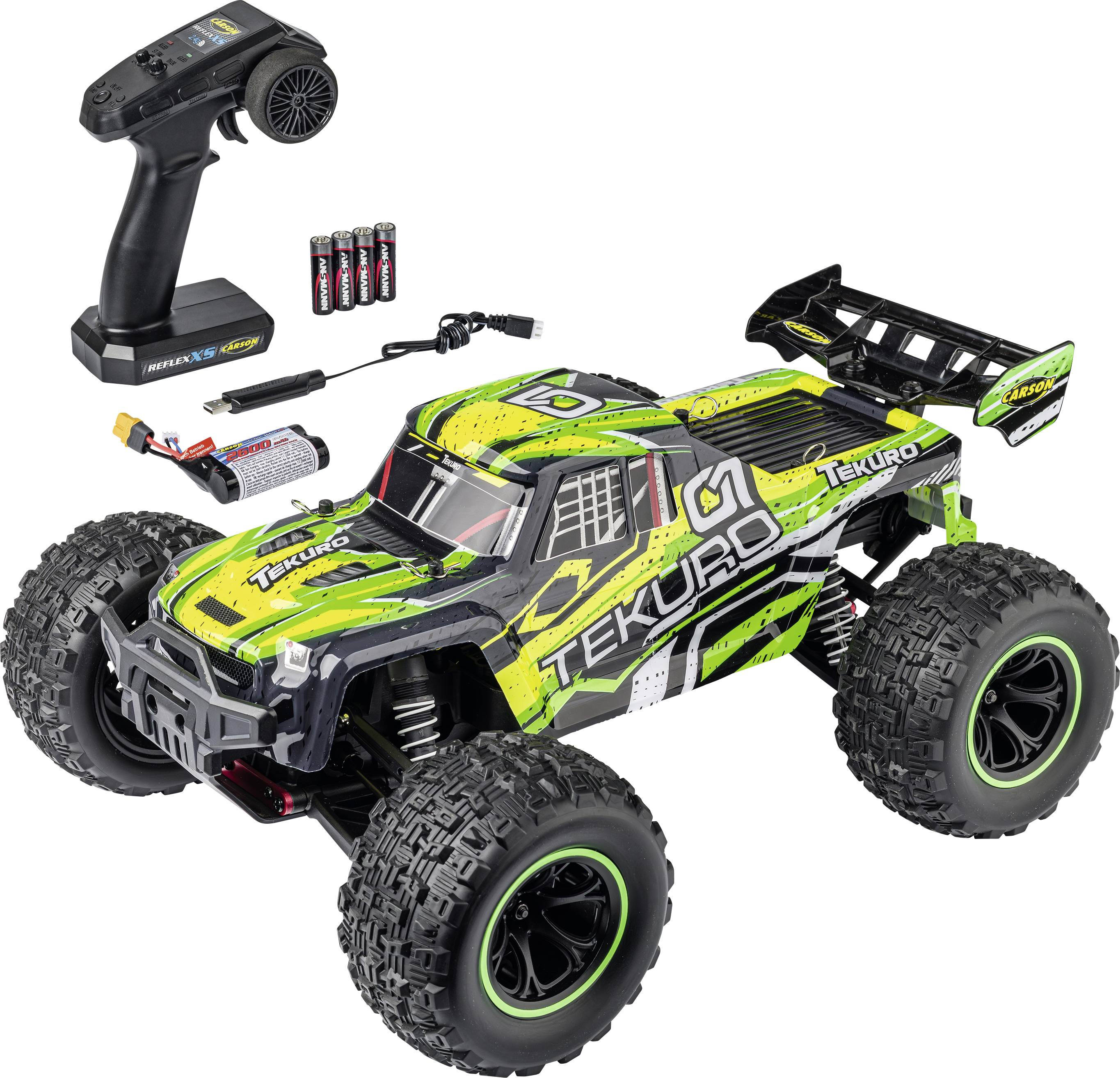 Fjernstyret off-road lastbilsæt med controller, batteri, oplader og reservedele på hvid baggrund.