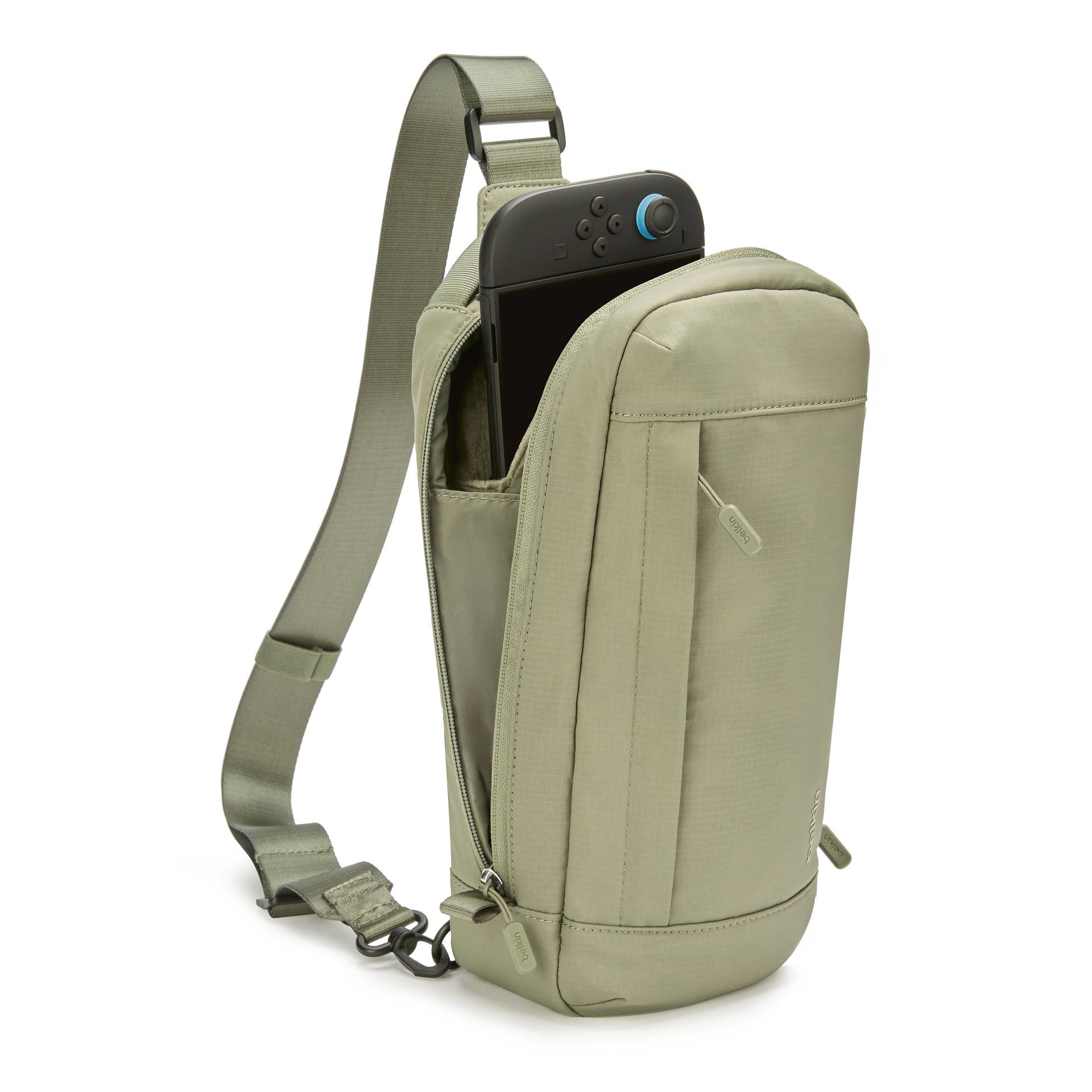 Beige crossbody-taske med justerbar rem, der rummer en sort bærbar spillekonsol, vist på en hvid baggrund.