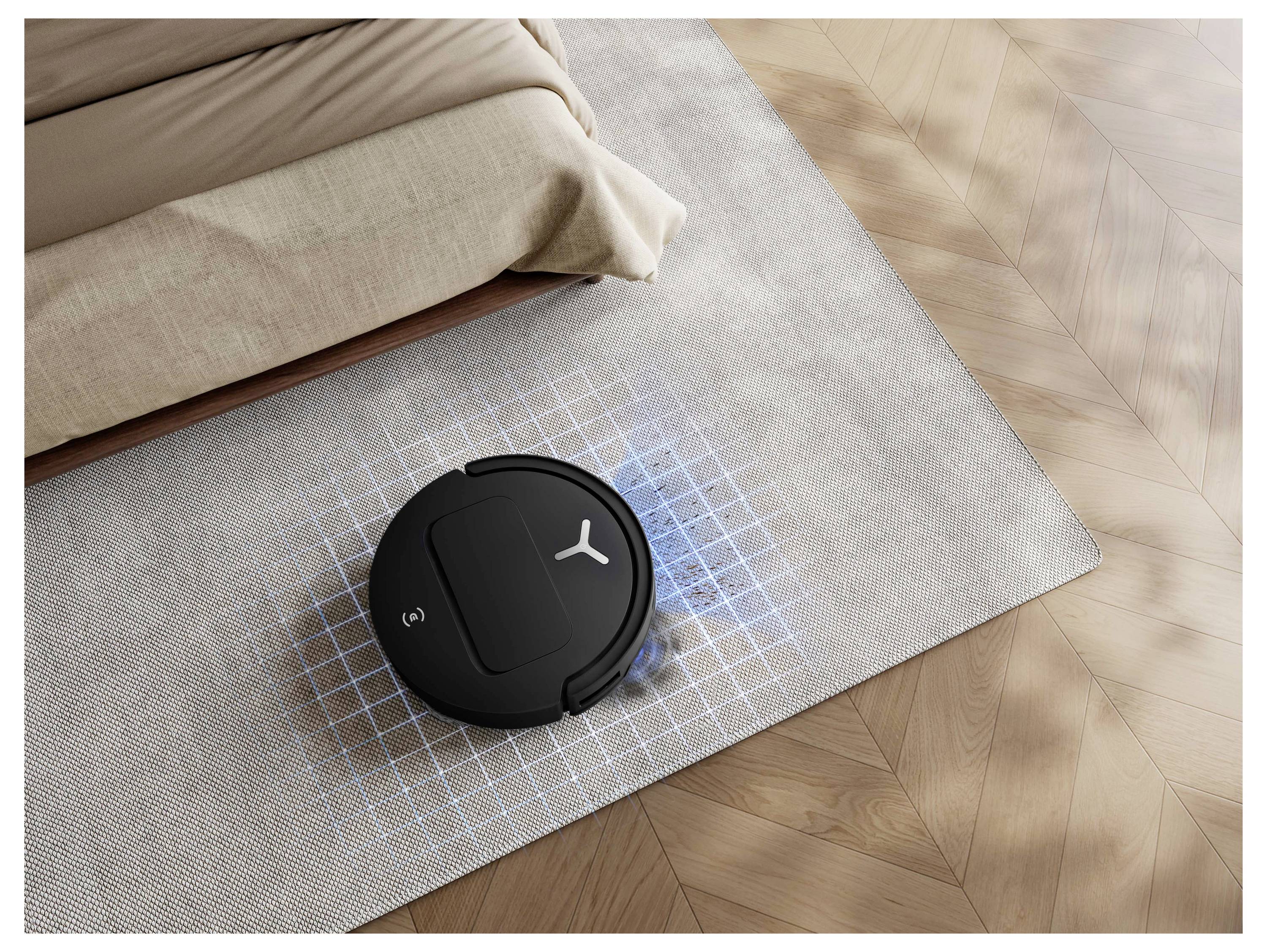 Sort robotstøvsuger rengør en stuegtæp ved siden af en sofa, med et blåt gitter, der viser dens kortlagte rengøringsområde.