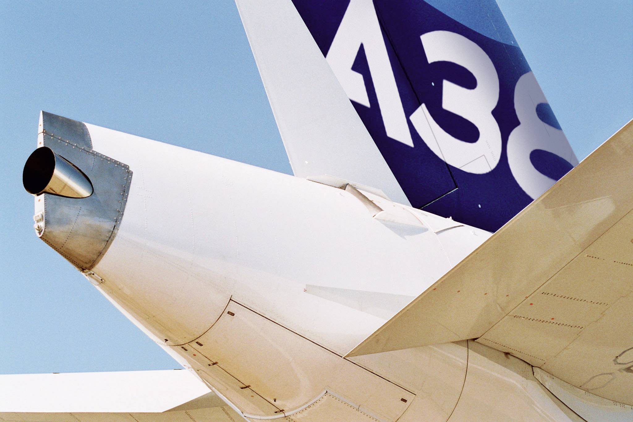 Halepartiet på et fly med synligt haleparti og motorudstødning mod en blå himmel. Nummeret 'A380' er tydeligt på halepartiet.