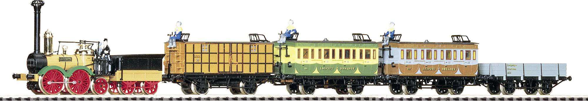 Legetøjstog i retrostil med farverig damplokomotiv og flere historiske togvogne i træ og metal.