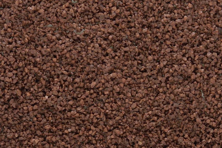 Nærbillede af rødligt granulat med ujævn struktur.