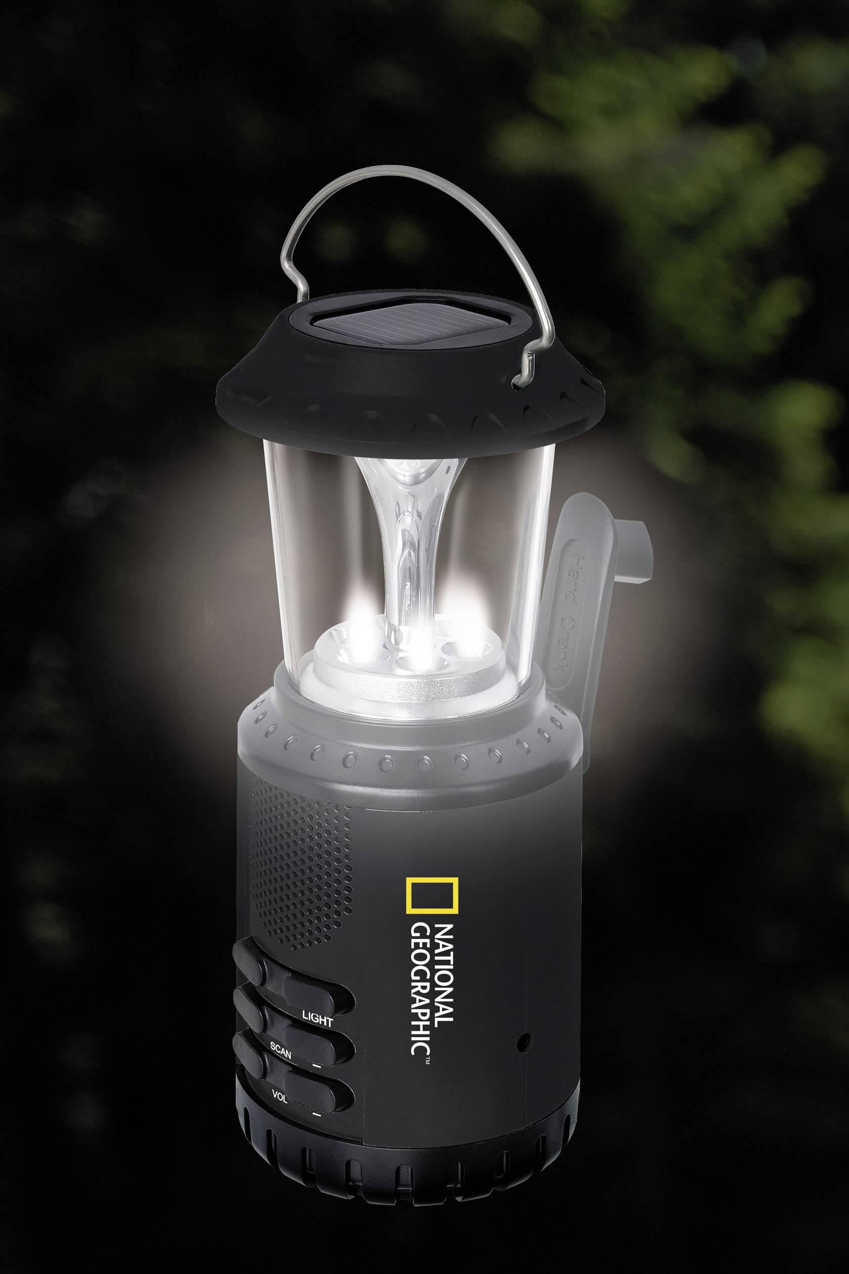 En sort lanterne med gennemsigtigt glas og lysende lys, forsynet med 'National Geographic'-logoet, foran en sløret naturbaggrund.