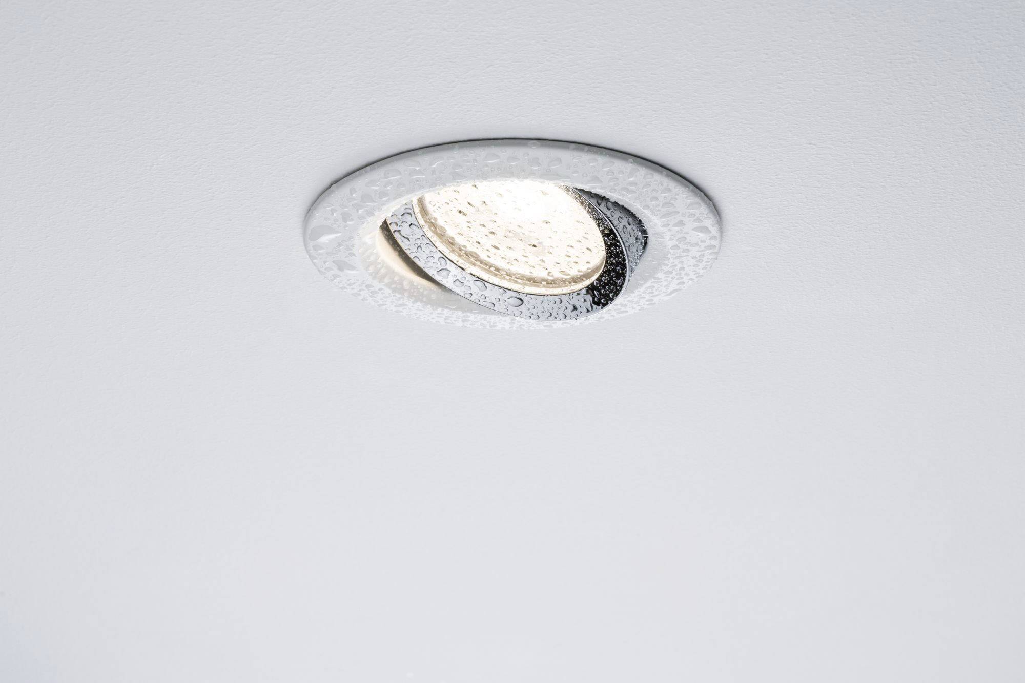 Loftlampe monteret i hvid loft, tændt og udsender lys.