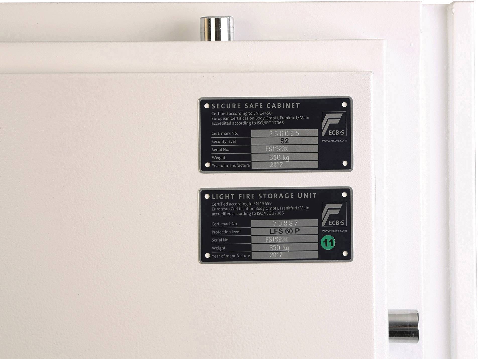 To skilte på et hvidt skab. Øverst: 'Secure Safe Cabinet', sikkerhedsniveau S2. Nederst: 'Light Fire Storage Unit', model 1060 P.