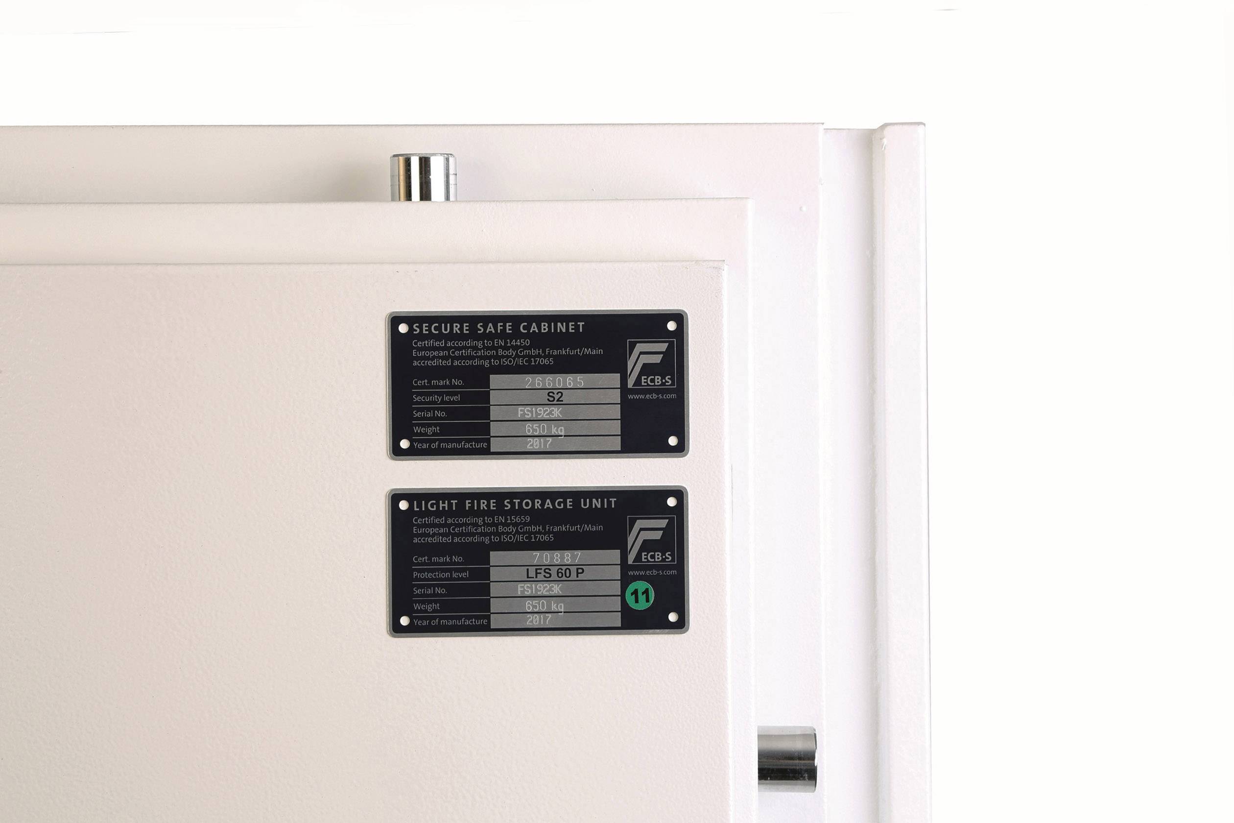 Et hvidt skab med to sorte informationsskilte: 'Secure Safe Cabinet' og 'Light Fire Storage Unit', begge med certificeringsdetaljer.