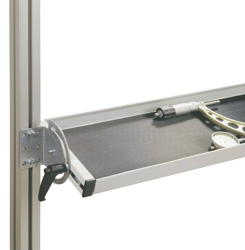 En værktøjsholder med skruetrækker og vinkelmål på en mørkstribet overflade, fastgjort til en metalramme.