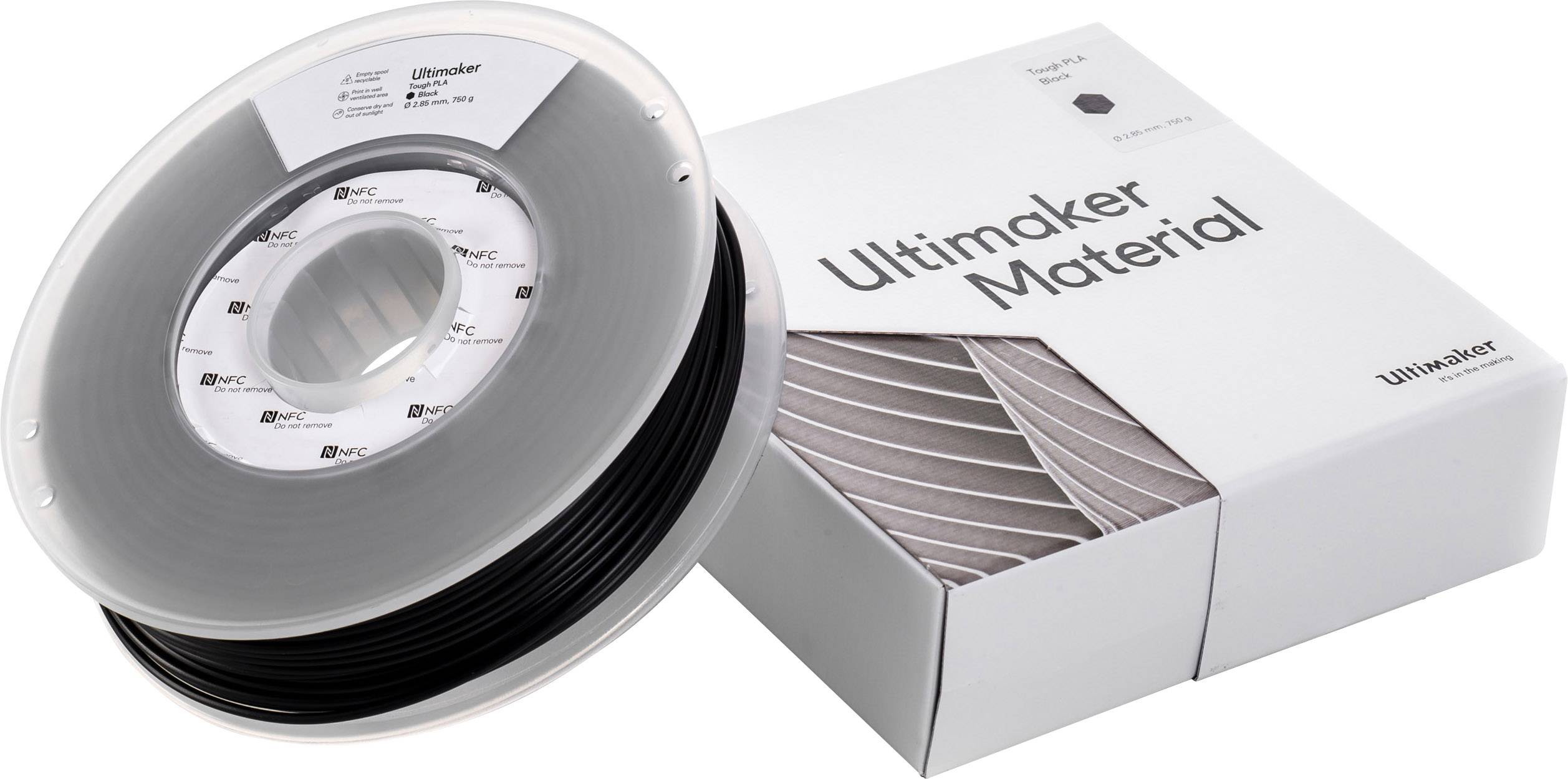 En rulle med sort 3D-printer-filament ved siden af en indpakning med teksten 'Ultimaker Material'.