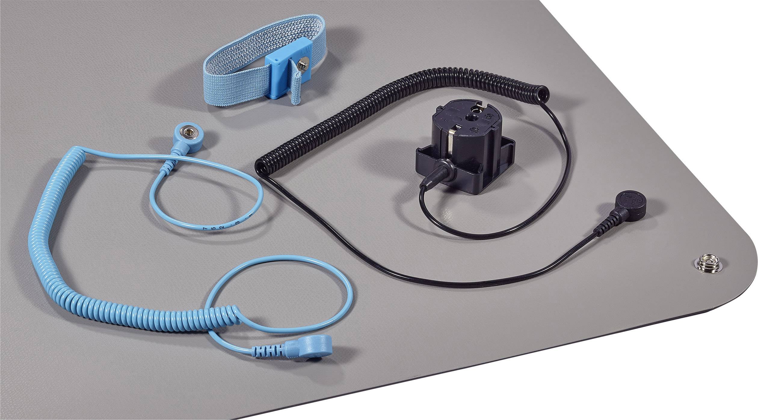 Forskellige elektroder og kabler på en grå overflade, herunder blå armbånd og sorte kabler, der bruges til medicinske enheder.