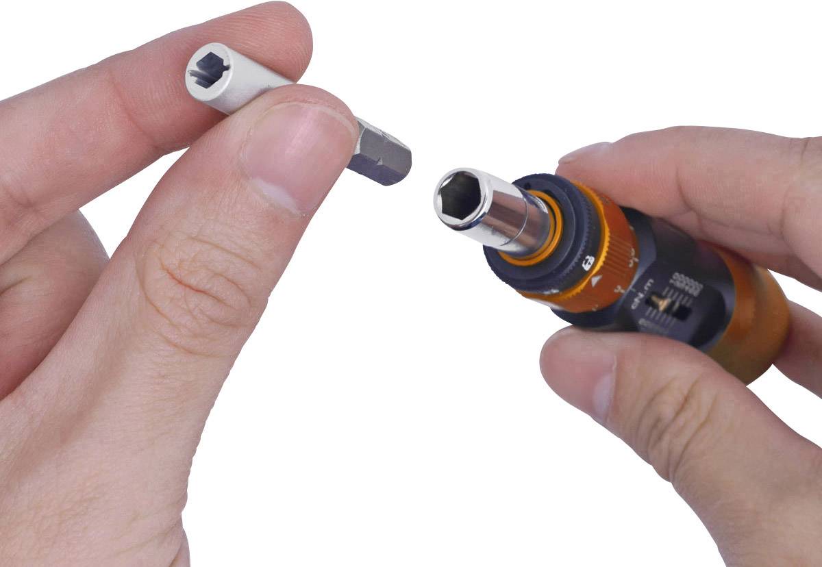Hænder holder en handy elektrisk skruemaskine med et afmonteret bits-sæt, klar til udskiftning eller indsætning.