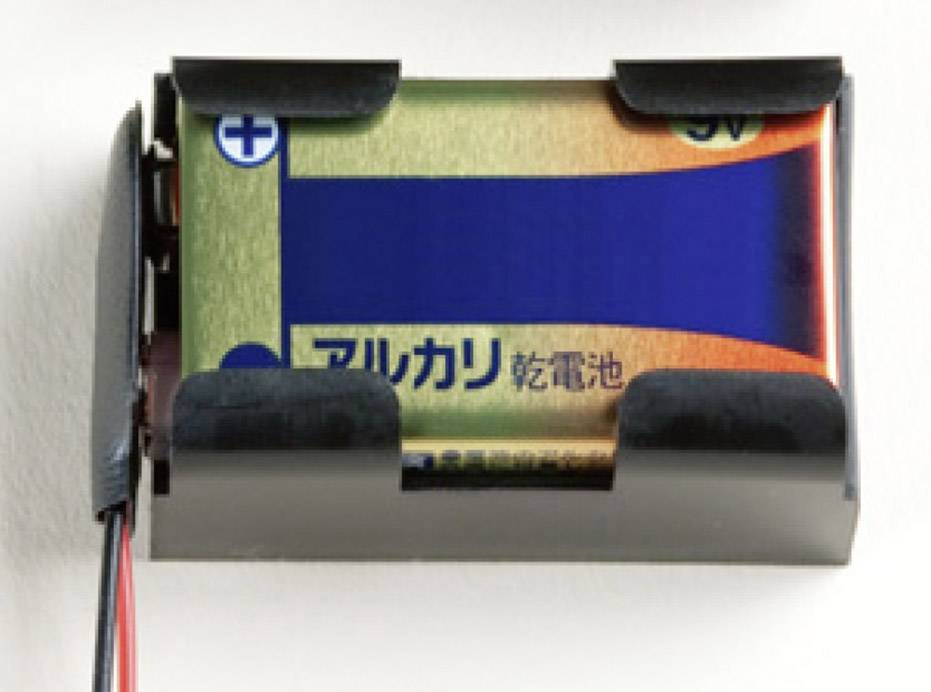Et 9V alkalisk batteri i en sort batteriholder med et rødt og et sort kabel fastgjort.