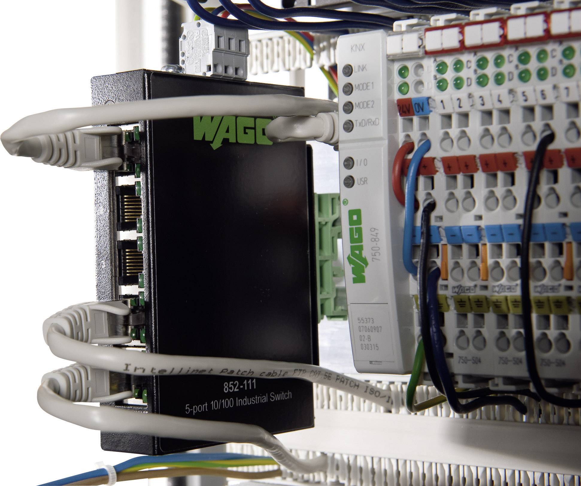 En industriel netværksswitch fra WAGO er forbundet med flere kabler og klemmer, hvilket viser en kabelføring.